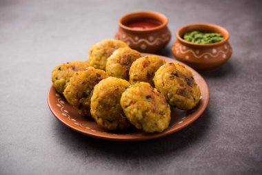 Vejetaryen Poha Pirzolası ya da yassı pirinç köftesi domates ketçap ve yeşil baharatla servis edilir.