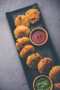 Vejetaryen Poha Pirzolası ya da yassı pirinç köftesi domates ketçap ve yeşil baharatla servis edilir.