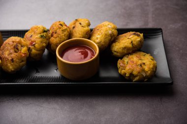 Vejetaryen Poha Pirzolası ya da yassı pirinç köftesi domates ketçap ve yeşil baharatla servis edilir.