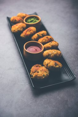 Vejetaryen Poha Pirzolası ya da yassı pirinç köftesi domates ketçap ve yeşil baharatla servis edilir.