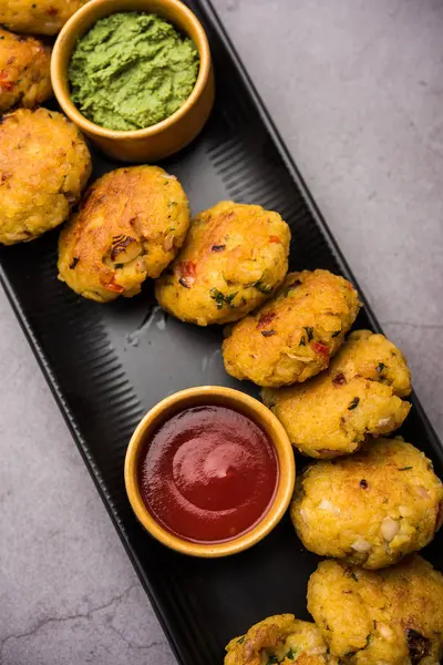 Veg Poha Cutlet or flattened Rice Patties served with tomato ketchup and green chutney