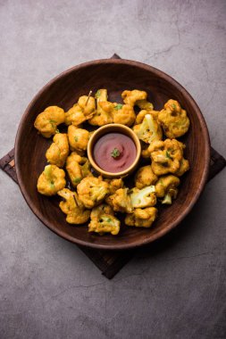 Gobi Pakora ya da Phoolgobi Pakoda taze nohut soslu nohut hamuru kullanıp yağda kızarttı. Domates ketçap ve nane sosuyla servis edilir. seçici odak