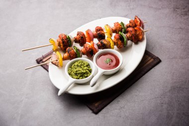 Barbekü ya da tandır mantarlı Tikka, yeşil turşu ve ketçaplı bir tabakta servis edilir. seçici odak