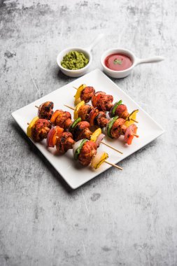 Barbekü ya da tandır mantarlı Tikka, yeşil turşu ve ketçaplı bir tabakta servis edilir. seçici odak