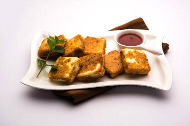 Amritsari Paneer Tikka besan, chat masala ve baharatlardan yapılmış süzme peynir küpleriyle tavada kızartılmış ve ketçapla servis edilmiş.