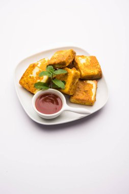 Amritsari Paneer Tikka besan, chat masala ve baharatlardan yapılmış süzme peynir küpleriyle tavada kızartılmış ve ketçapla servis edilmiş.