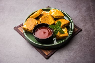 Amritsari Paneer Tikka besan, chat masala ve baharatlardan yapılmış süzme peynir küpleriyle tavada kızartılmış ve ketçapla servis edilmiş.