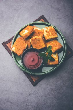 Amritsari Paneer Tikka besan, chat masala ve baharatlardan yapılmış süzme peynir küpleriyle tavada kızartılmış ve ketçapla servis edilmiş.