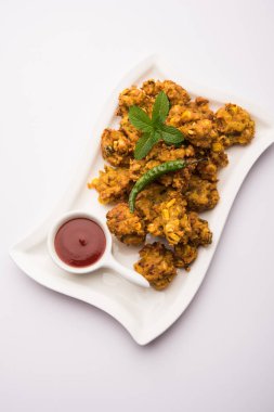 Çıtır mısır pakora / pakoda, bhajji, Bhaji, bajji veya pattice. Domates ve ketçap ile servis edilir.