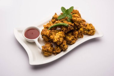Çıtır mısır pakora / pakoda, bhajji, Bhaji, bajji veya pattice. Domates ve ketçap ile servis edilir.