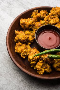 Çıtır mısır pakora / pakoda, bhajji, Bhaji, bajji veya pattice. Domates ve ketçap ile servis edilir.