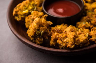 Çıtır mısır pakora / pakoda, bhajji, Bhaji, bajji veya pattice. Domates ve ketçap ile servis edilir.