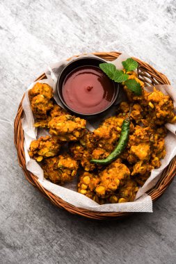 Çıtır mısır pakora / pakoda, bhajji, Bhaji, bajji veya pattice. Domates ve ketçap ile servis edilir.