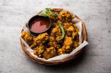 Çıtır mısır pakora / pakoda, bhajji, Bhaji, bajji veya pattice. Domates ve ketçap ile servis edilir.