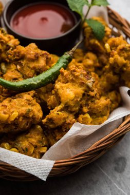 Çıtır mısır pakora / pakoda, bhajji, Bhaji, bajji veya pattice. Domates ve ketçap ile servis edilir.