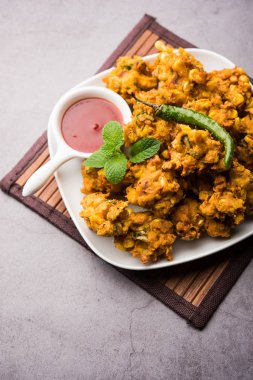Çıtır mısır pakora / pakoda, bhajji, Bhaji, bajji veya pattice. Domates ve ketçap ile servis edilir.