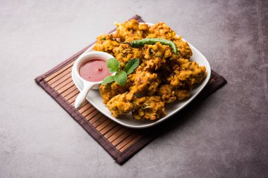 Çıtır mısır pakora / pakoda, bhajji, Bhaji, bajji veya pattice. Domates ve ketçap ile servis edilir.