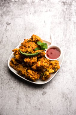 Çıtır mısır pakora / pakoda, bhajji, Bhaji, bajji veya pattice. Domates ve ketçap ile servis edilir.