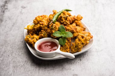 Çıtır mısır pakora / pakoda, bhajji, Bhaji, bajji veya pattice. Domates ve ketçap ile servis edilir.