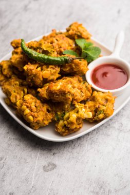 Çıtır mısır pakora / pakoda, bhajji, Bhaji, bajji veya pattice. Domates ve ketçap ile servis edilir.