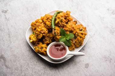 Çıtır mısır pakora / pakoda, bhajji, Bhaji, bajji veya pattice. Domates ve ketçap ile servis edilir.