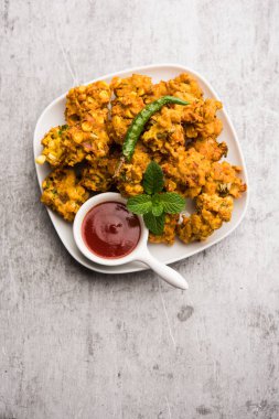 Çıtır mısır pakora / pakoda, bhajji, Bhaji, bajji veya pattice. Domates ve ketçap ile servis edilir.