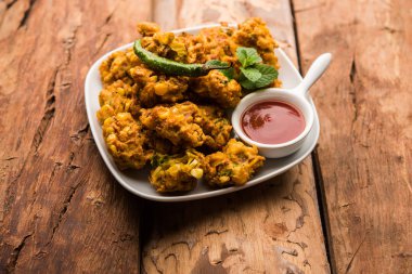 Çıtır mısır pakora / pakoda, bhajji, Bhaji, bajji veya pattice. Domates ve ketçap ile servis edilir.