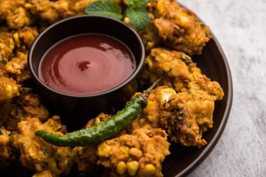 Çıtır mısır pakora / pakoda, bhajji, Bhaji, bajji veya pattice. Domates ve ketçap ile servis edilir.