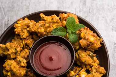 Çıtır mısır pakora / pakoda, bhajji, Bhaji, bajji veya pattice. Domates ve ketçap ile servis edilir.