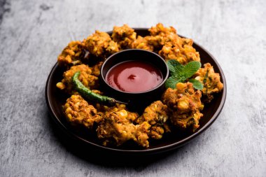 Çıtır mısır pakora / pakoda, bhajji, Bhaji, bajji veya pattice. Domates ve ketçap ile servis edilir.