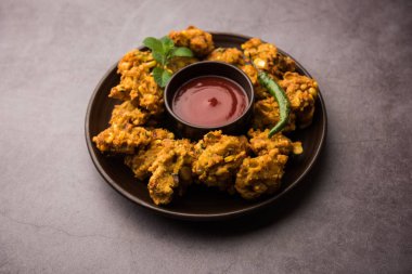 Çıtır mısır pakora / pakoda, bhajji, Bhaji, bajji veya pattice. Domates ve ketçap ile servis edilir.
