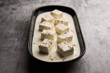 Paneer Dum Kali Mirch / Kalimirch, üzerine beyaz kremalı sos ve karabiber tozu serpiştirilmiş. Bir kasede servis edilir. Seçici odak