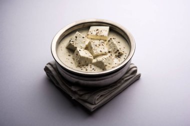 Paneer Dum Kali Mirch / Kalimirch, üzerine beyaz kremalı sos ve karabiber tozu serpiştirilmiş. Bir kasede servis edilir. Seçici odak