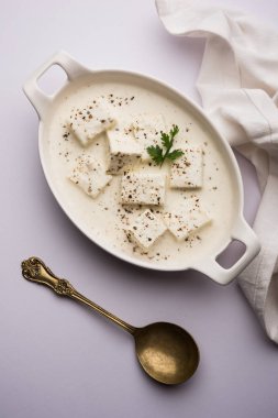 Paneer Dum Kali Mirch / Kalimirch, üzerine beyaz kremalı sos ve karabiber tozu serpiştirilmiş. Bir kasede servis edilir. Seçici odak