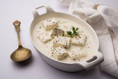 Paneer Dum Kali Mirch / Kalimirch, üzerine beyaz kremalı sos ve karabiber tozu serpiştirilmiş. Bir kasede servis edilir. Seçici odak