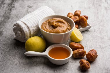 Yumuşak, pürüzsüz ve pürüzsüz cilt maskesi ve taze çiğ khajoor, limon ve bal gibi renkler. seçici odak