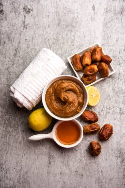 Yumuşak, pürüzsüz ve pürüzsüz cilt maskesi ve taze çiğ khajoor, limon ve bal gibi renkler. seçici odak