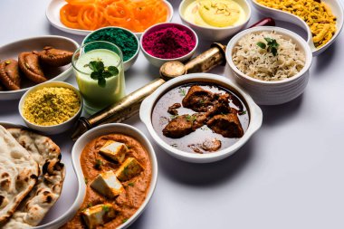 Hindistanın tavuk, paneer yağı masala, naan, jeera pilavı, siyah chana kızartması, jalebi, fujiyama, thandai ve Farsan gibi çeşitli öğle yemeği çeşitlerini gösteren kutsal konsept. 
