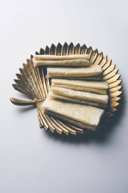 Pootharekulu  is a popular recipe originated from Andhra Pradesh, India.It is a paper-thin sweet or dessert made from rice start/gram flour, jaggery/sugar and clarified butter. Served in a plate.