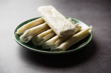 Pootharekulu  is a popular recipe originated from Andhra Pradesh, India.It is a paper-thin sweet or dessert made from rice start/gram flour, jaggery/sugar and clarified butter. Served in a plate.