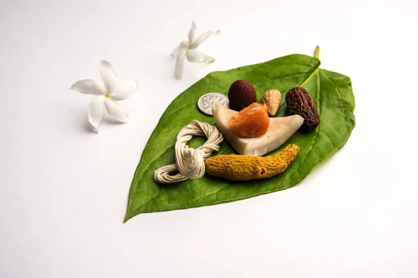 Hindu Puja with betel leaf, supari, janeu, almond, dates, turmeric, dried coconut and jaggery with 1 rupee coin. Important item in Vedic rituals. selective focus