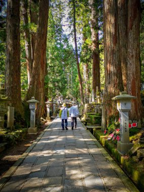 Pilgrims walking the long path in the Okunion cemetery towards the Kobo Daishi mausoleum in the UNesco WOrld Heritage site Koyasan in Kansai, Japan