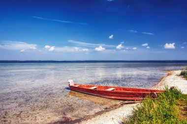 Manzara - ahşap balıkçı teknesi, göl, sazlık kumsalda.