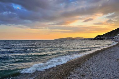 Deniz sahilinde gün batımı.