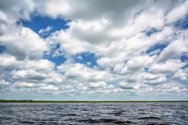 Mavi gökyüzü göl üzerinde bulutlar ile.