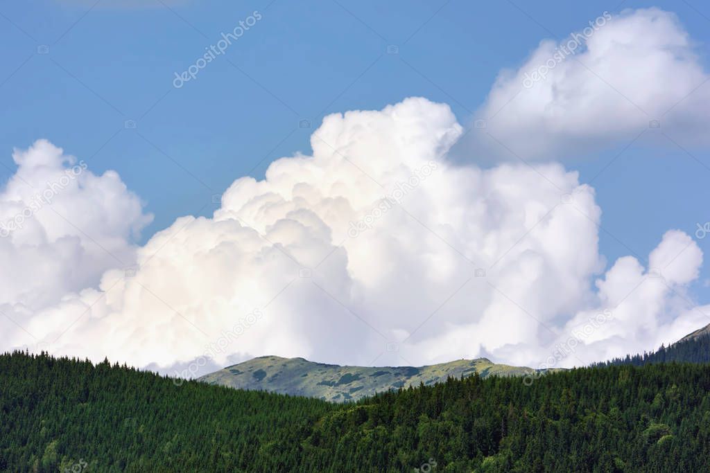 Mountains, forests and sky with clouds.