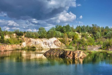 Bir orman gölünün kayalık kıyısı.