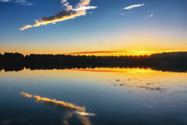 Gölün üzerinde gün batımı - Suya yansıyan kıyı silueti.