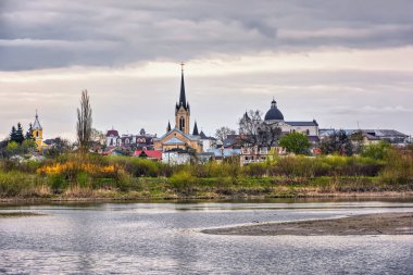 Bahar manzarası - kiliseleri, tapınakları ve bulutlu bir günde parkı olan nehir kıyısı (Lutsk, Ukrayna).
