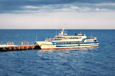 Rıhtımda, denizde ve gökyüzünde eğlence teknesi.